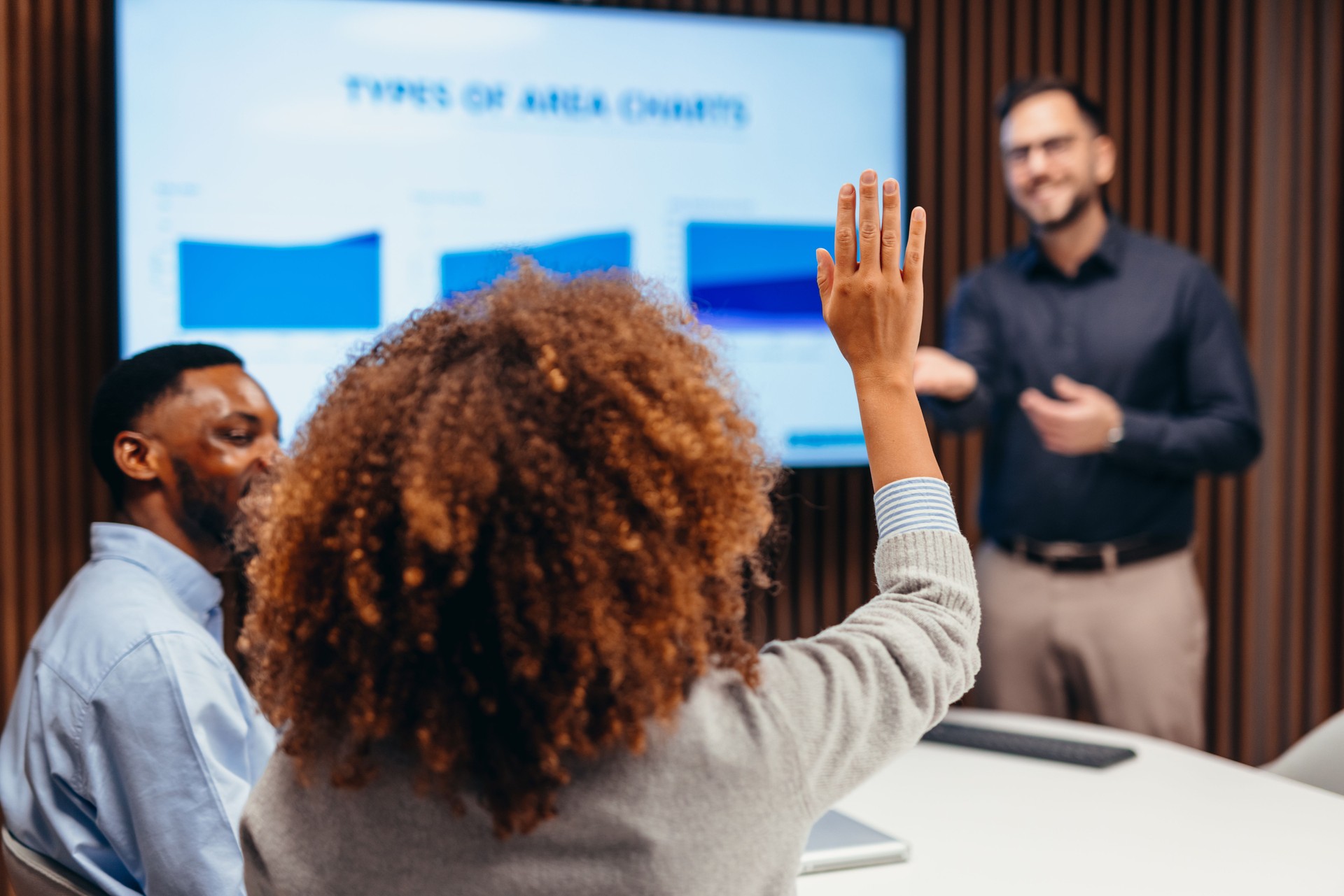 Businesswoman raising hand during a business meeting asking a question to the speaker